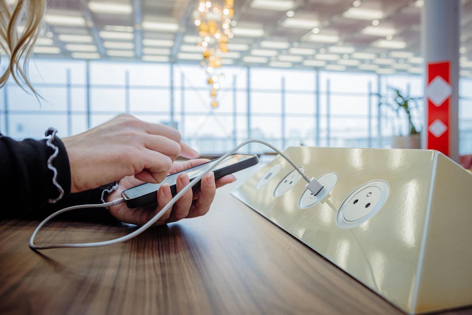Personne rechargeant son téléphone dans un lieu public