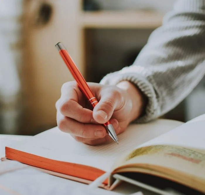 Mains en train d'&eacute;crire, l'une tenant un stylo