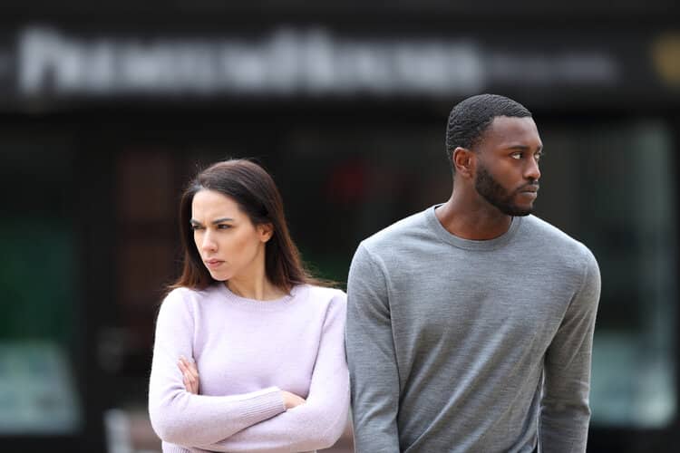 Couple assis dos à dos avec une expression distante