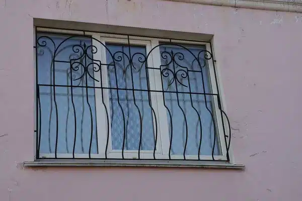 Fenêtre blanche avec grille noire aux motifs arrondis