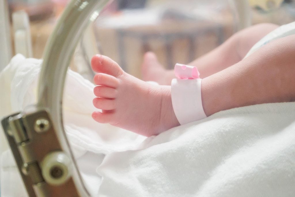 Parents regardant un nouveau-né en couveuse avec émotion