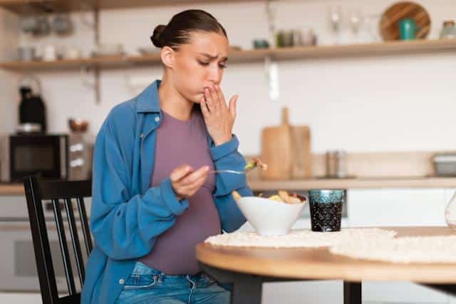 Personne se tenant la mâchoire avec une expression de dégoût