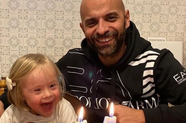 Un motard, veste de cuir, regardant au loin avec douceur