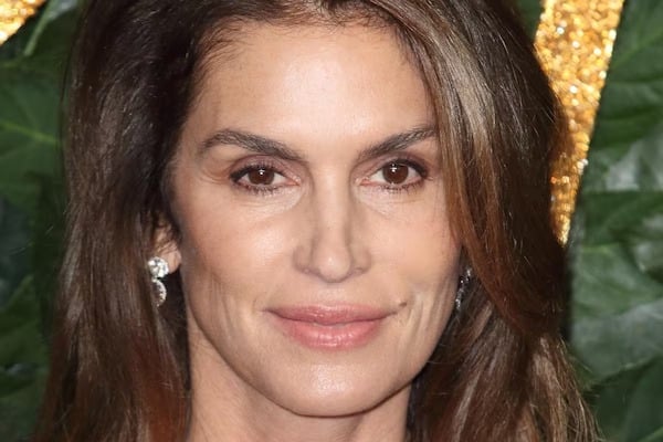 Cindy Crawford souriante, arborant des cheveux l&eacute;g&egrave;rement argent&eacute;s avec naturel