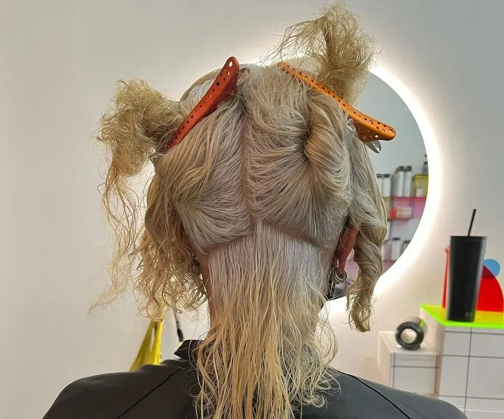 Femme se coiffant devant un miroir