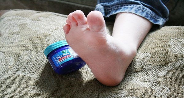 Personne appliquant du Vicks VapoRub sur le pied
