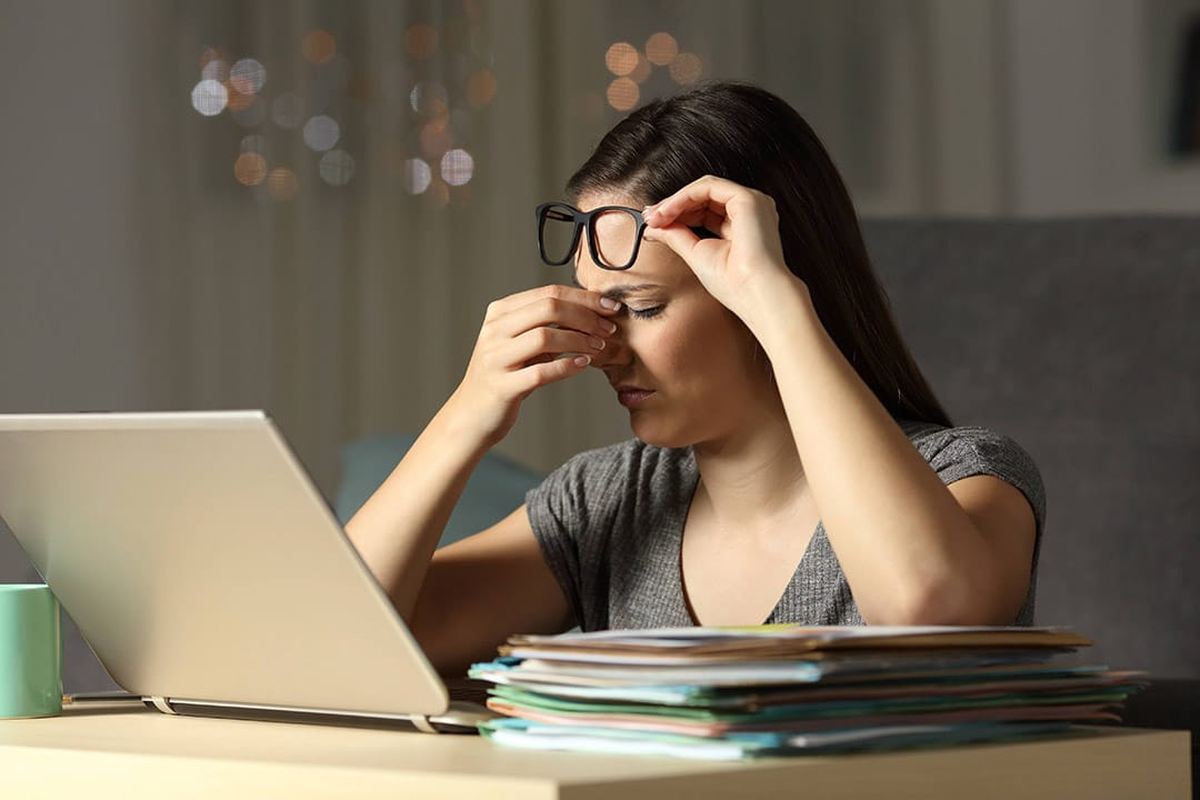 Femme épuisée tenant sa tête entre ses mains