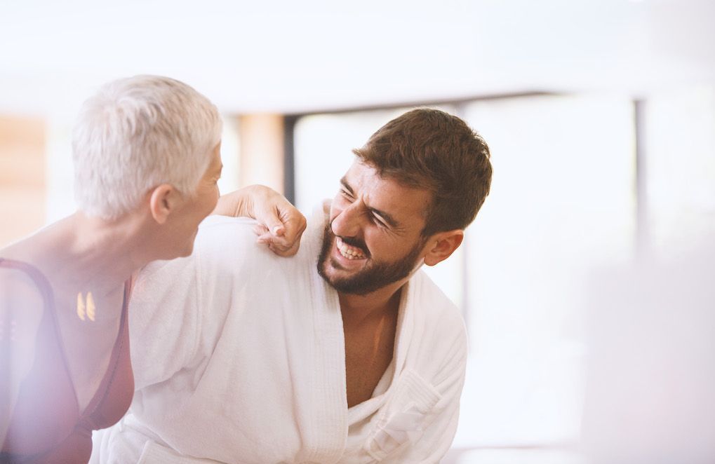 Femme souriante et épanouie en compagnie d'un homme plus jeune, dans un moment de complicité détendu