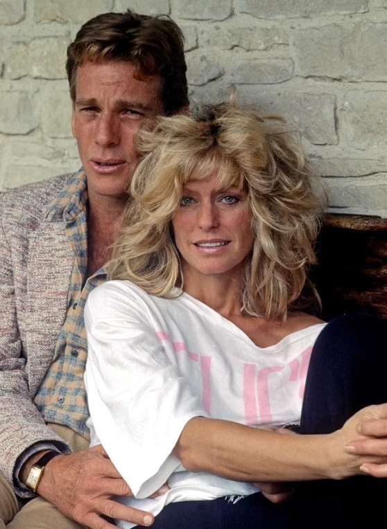Ryan O'Neal et Farrah Fawcett souriants et enlacés