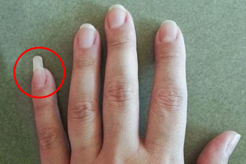 Homme utilisant son ongle long de l'auriculaire comme outil pratique
