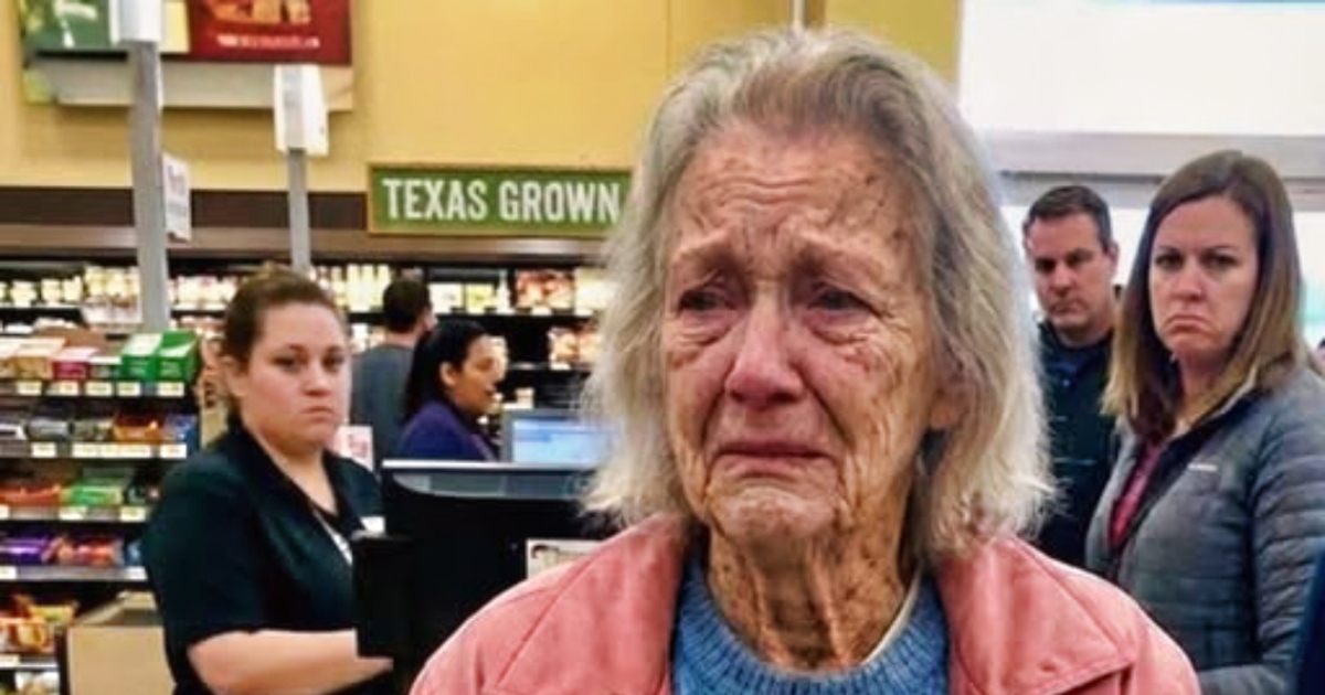 Une femme dans un supermarch&eacute;, observant une personne &acirc;g&eacute;e &agrave; la caisse