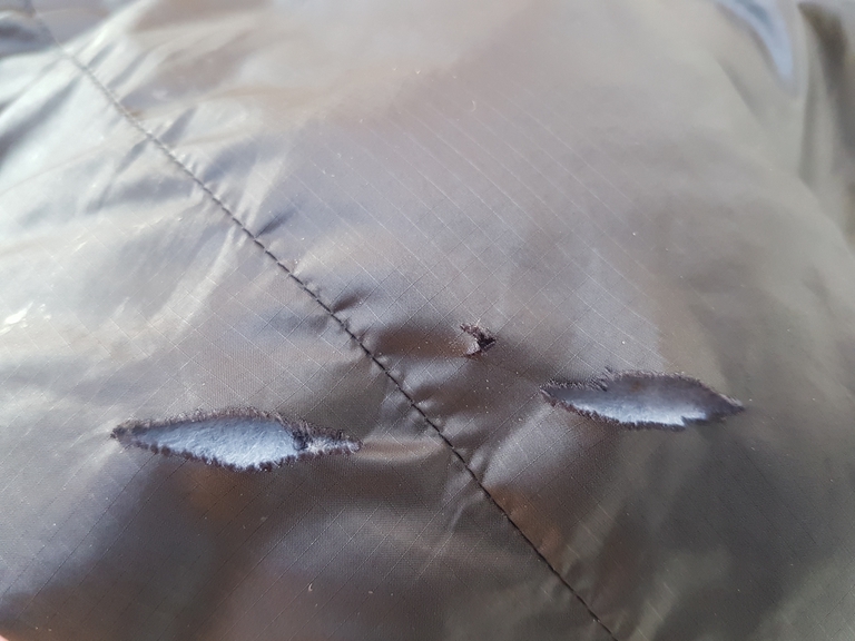 D&eacute;tail d'une d&eacute;chirure sur une doudoune