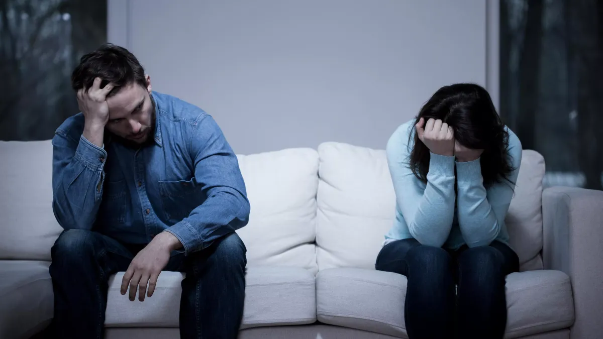 Femme assise seule sur un canapé regardant son alliance