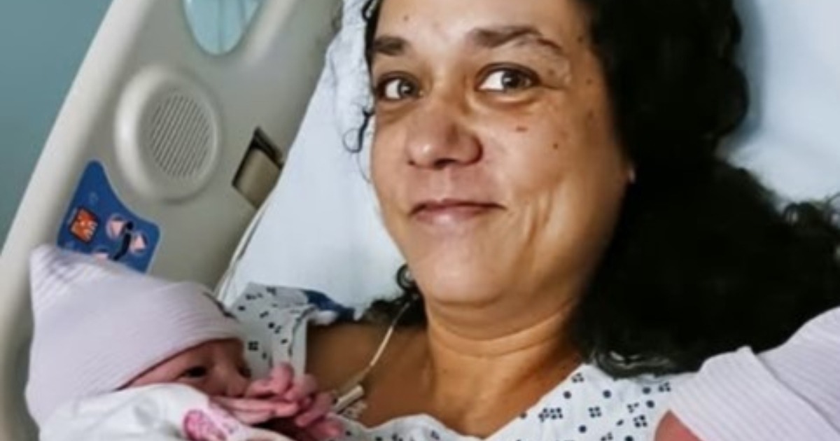 Une femme d'&acirc;ge m&ucirc;r, Claire, regarde une &eacute;chographie avec une expression m&eacute;lang&eacute;e de surprise et d'&eacute;motion.