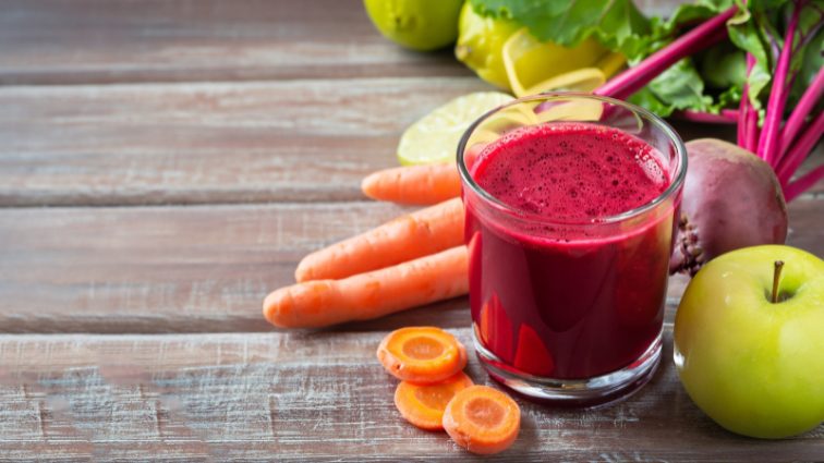 Jus vitaminé de betterave, carotte et pomme dans un verre