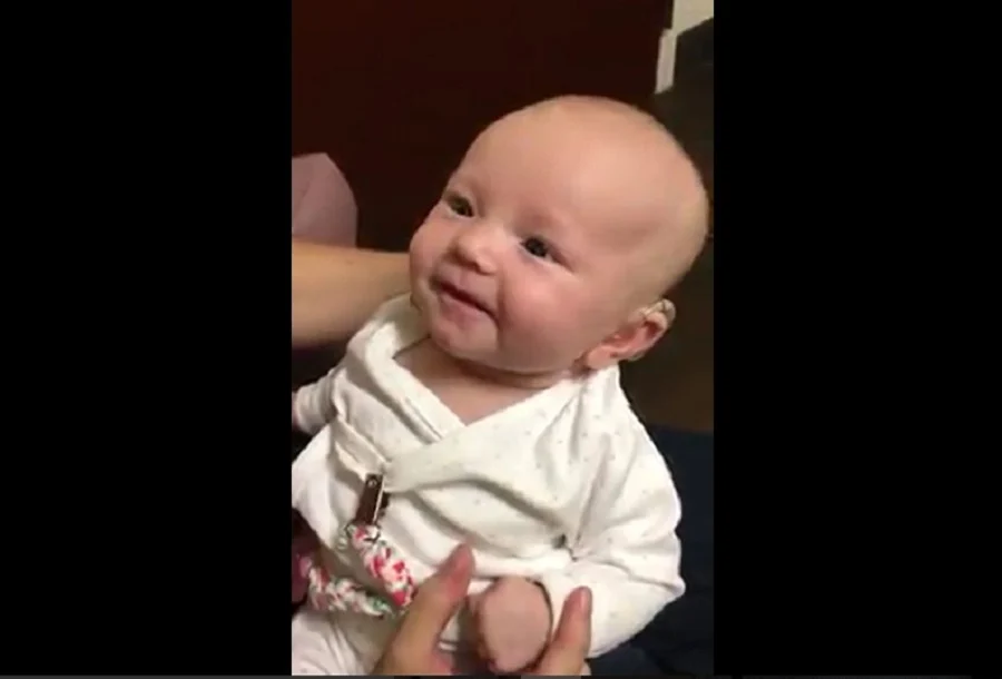Sourire émouvant de la petite fille sourde entendant sa maman