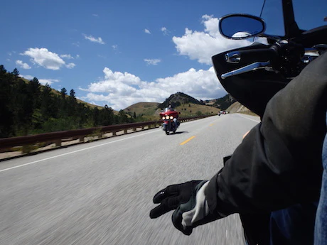 Motard faisant un signe de la main sur sa moto