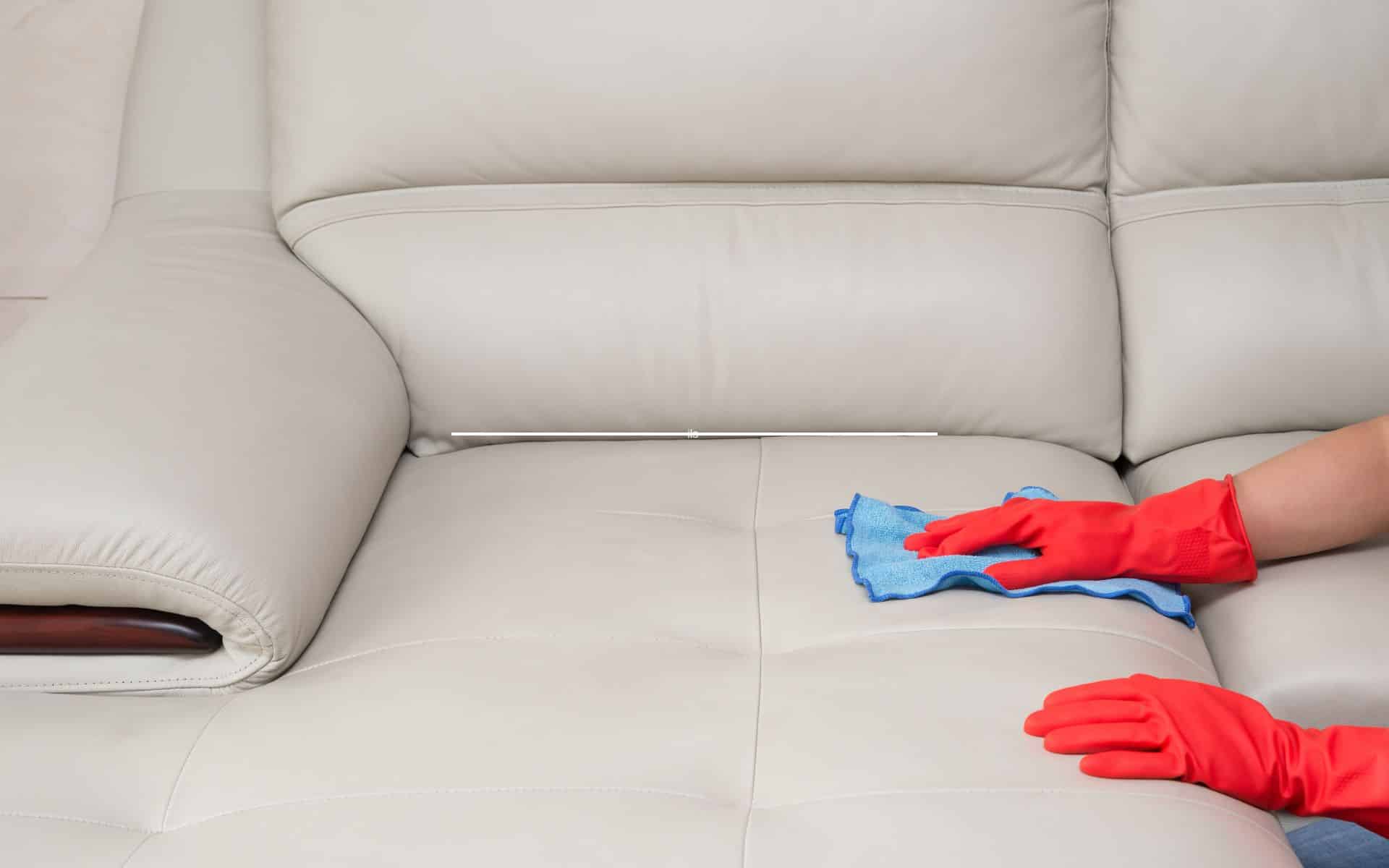 Application d'une pâte de bicarbonate sur un canapé en cuir taché