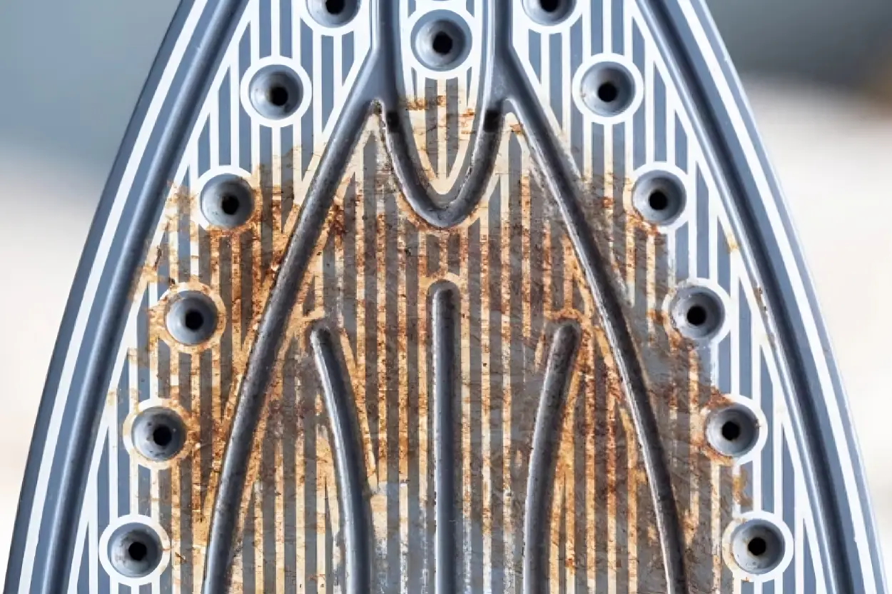 D&eacute;tail d'une semelle de fer &agrave; repasser noircie et encrass&eacute;e