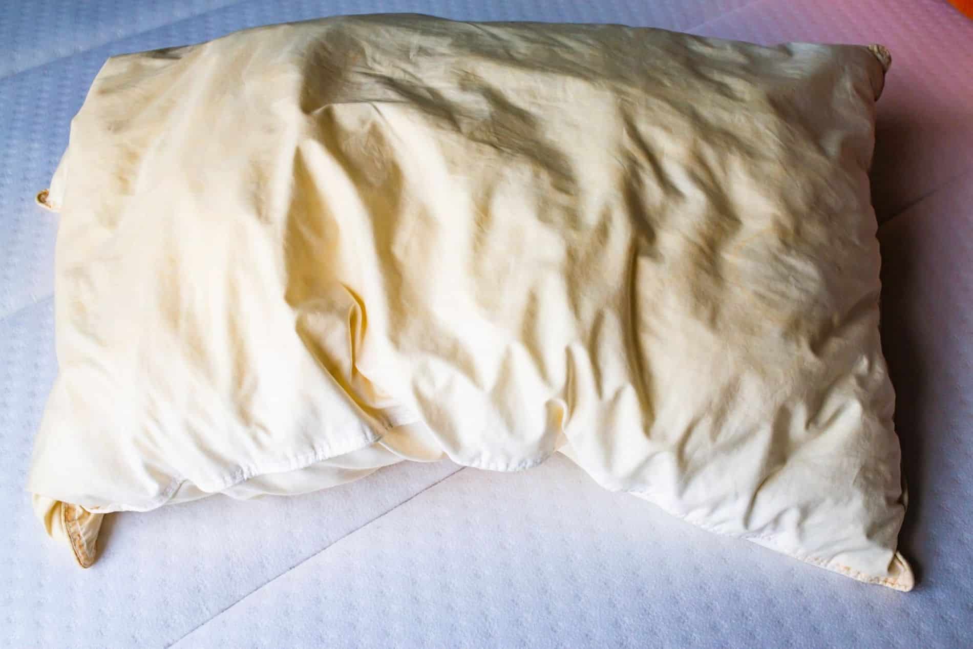 Oreiller blanc marqu&eacute; par des taches jaun&acirc;tres