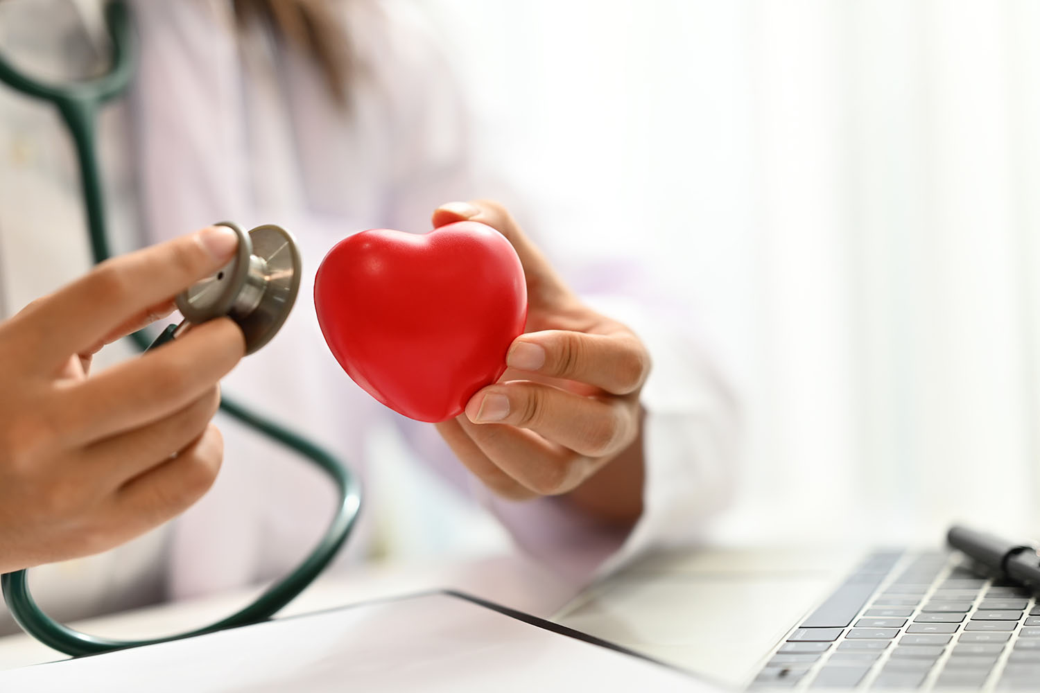 Médecin tenant un stéthoscope et un cœur rouge symbolique