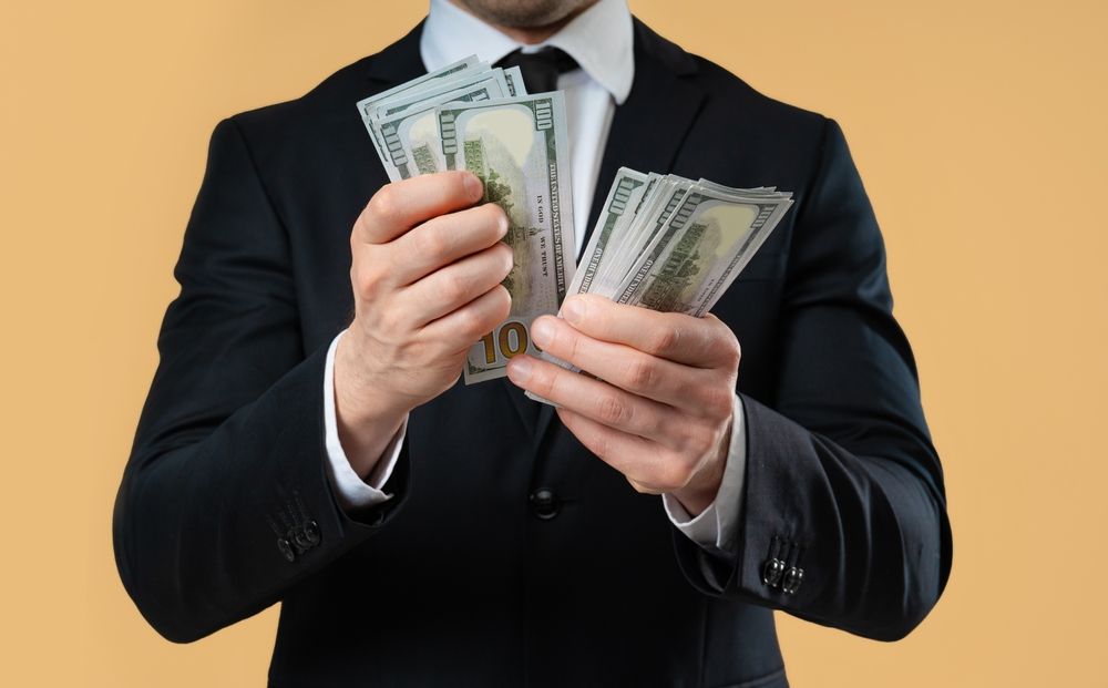 Femme consultant ses finances sur un ordinateur portable, avec des documents et une calculatrice, l'air concentrée et sereine