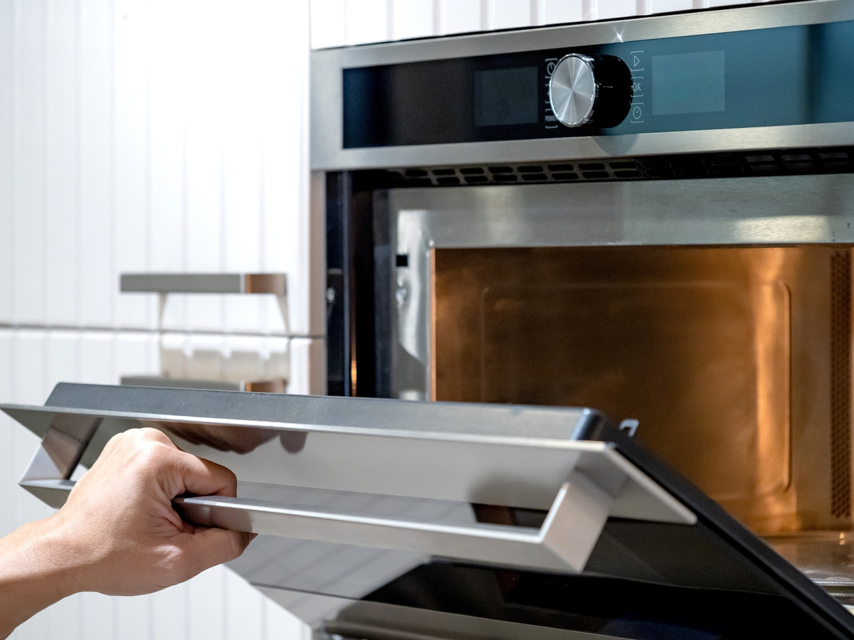 Femme nettoyant un four avec des produits adapt&eacute;s